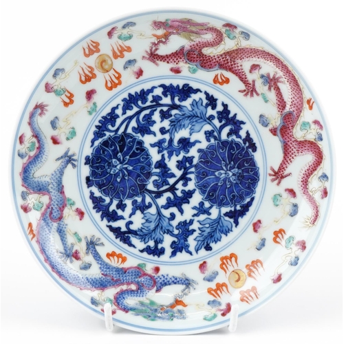 264 - A Chinese porcelain footed plate hand painted with dragons amongst clouds chasing the flaming pearl,... 