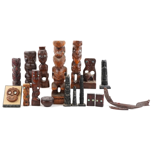 A collection of New Zealand Māori carved figures and Canadian carved slate tribal poles, the largest 42cm high.