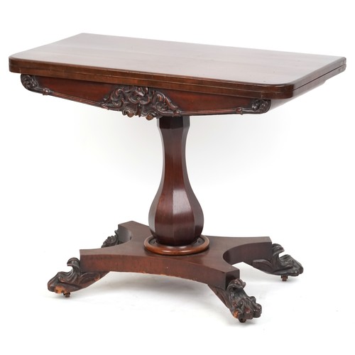 1046 - A Victorian mahogany fold-over card table, the carved frieze raised on a baluster column, platform b... 