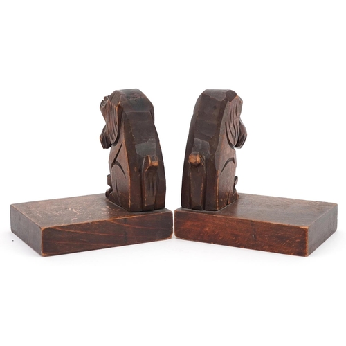 1168 - A pair of naive continental carved walnut bookends in the form of seated terriers, 12cm H x 11cm W x... 