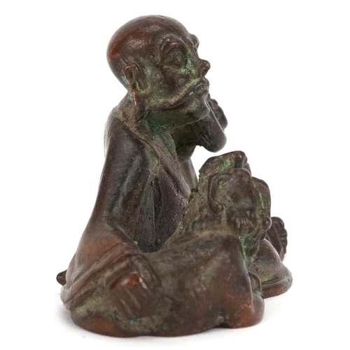 1157 - A Japanese patinated bronze okimono of a gentleman and Foo dog, impressed marks to the base, 6.5cm i... 