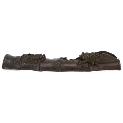 1315 - A Japanese patinated bronze study of two insects on bamboo, impressed marks, 16cm in length.