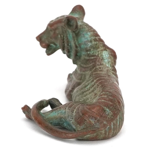 1336 - A Japanese patinated bronze okimono of a tiger, impressed marks, 7cm in length.