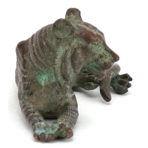 1336 - A Japanese patinated bronze okimono of a tiger, impressed marks, 7cm in length.