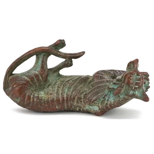 1336 - A Japanese patinated bronze okimono of a tiger, impressed marks, 7cm in length.