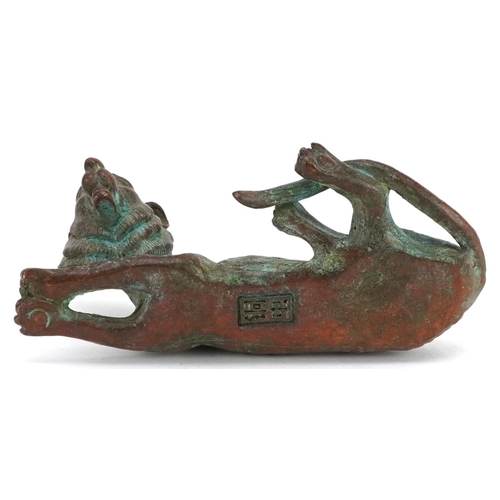 1336 - A Japanese patinated bronze okimono of a tiger, impressed marks, 7cm in length.