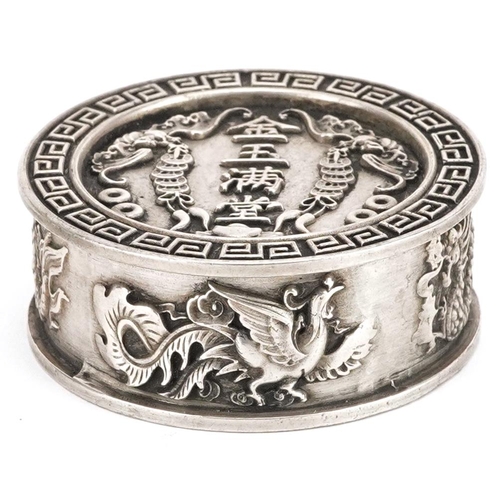 1165 - A Chinese white metal circular box and cover decorated with dragons and bats, 5cm in diameter, 106.2... 