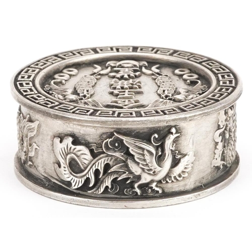 1165 - A Chinese white metal circular box and cover decorated with dragons and bats, 5cm in diameter, 106.2... 