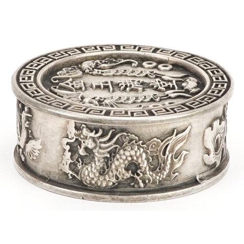 1165 - A Chinese white metal circular box and cover decorated with dragons and bats, 5cm in diameter, 106.2... 