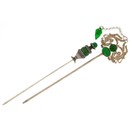 1254 - Two Middle Eastern white metal hairpins set with green stones, the largest 17cm in length.