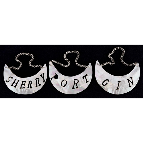 1344 - A set of three mother of pearl decanter labels with white metal chains, each 6.5cm wide.