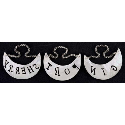 1344 - A set of three mother of pearl decanter labels with white metal chains, each 6.5cm wide.