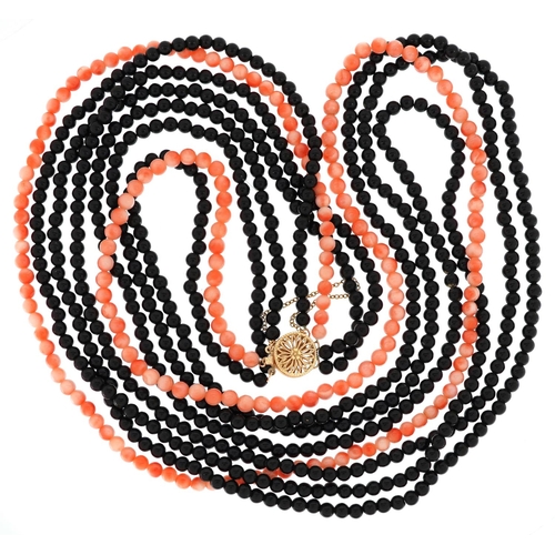 2534 - A pink coral and black bead four row necklace with 14ct gold clasp, 76cm in length, 87.0g.