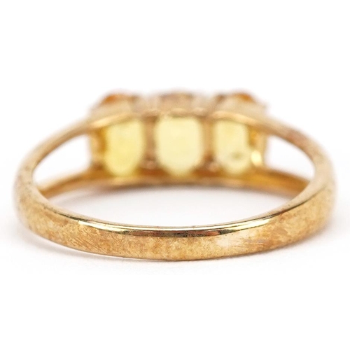 2208 - A 9ct gold yellow topaz three stone ring, size N, 2.4g.