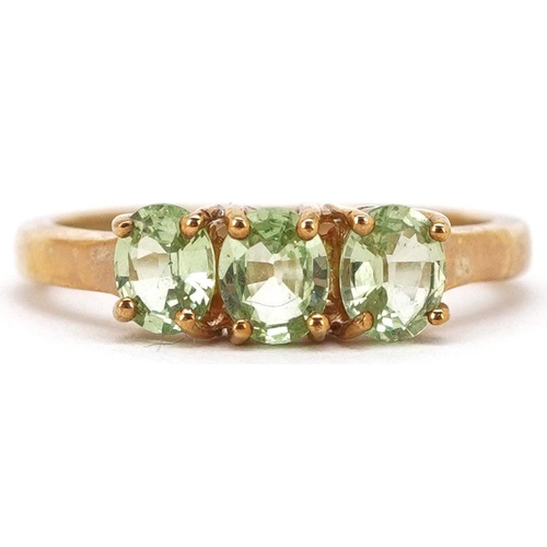 2292 - A 9ct gold green amethyst three stone ring, size N, 2.2g.