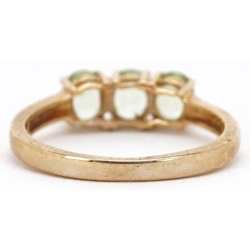 2292 - A 9ct gold green amethyst three stone ring, size N, 2.2g.