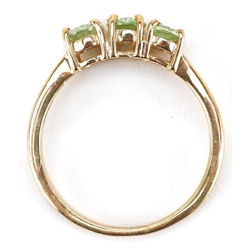 2292 - A 9ct gold green amethyst three stone ring, size N, 2.2g.