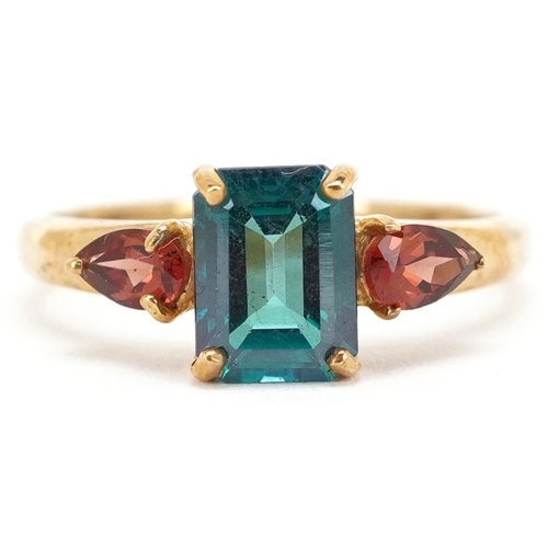 2162 - A 9ct gold rectangular cut green topaz ring with garnet set shoulders, size N, 2.5g.