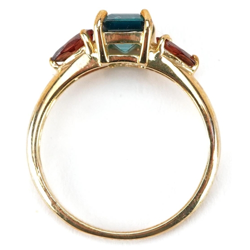 2162 - A 9ct gold rectangular cut green topaz ring with garnet set shoulders, size N, 2.5g.