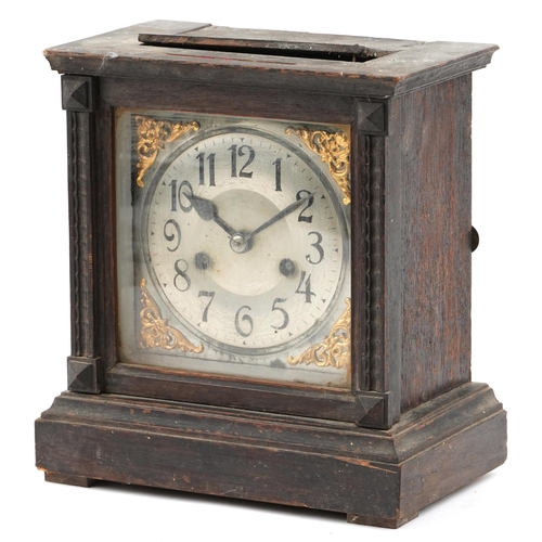 1252 - An early 20th century oak cased mantle clock, the silvered dial raised on a plinth base, with pendul... 