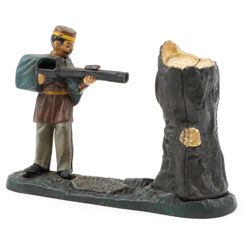 535 - An early 20th century Book of Knowledge cast iron and hand painted coin bank modelled as a man shoot... 