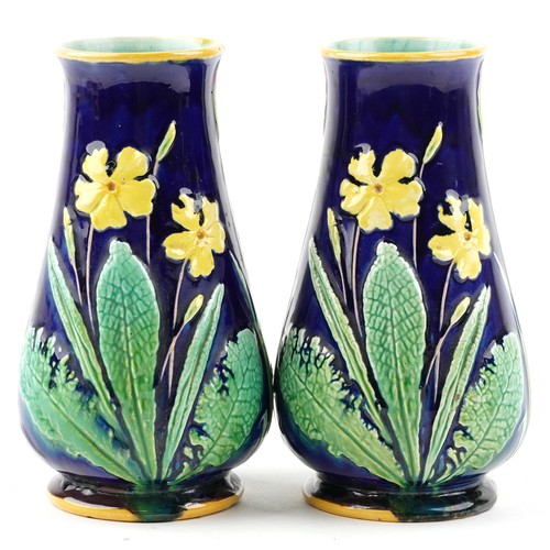 1288 - A pair of early 20th century Majolica pottery vases, each with floral decoration, bearing impressed ... 