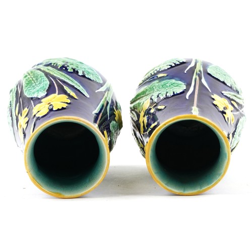 1288 - A pair of early 20th century Majolica pottery vases, each with floral decoration, bearing impressed ... 