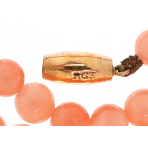 2158 - A pink coral bead necklace with 9ct gold clasp, 40cm in length, 9.0g.