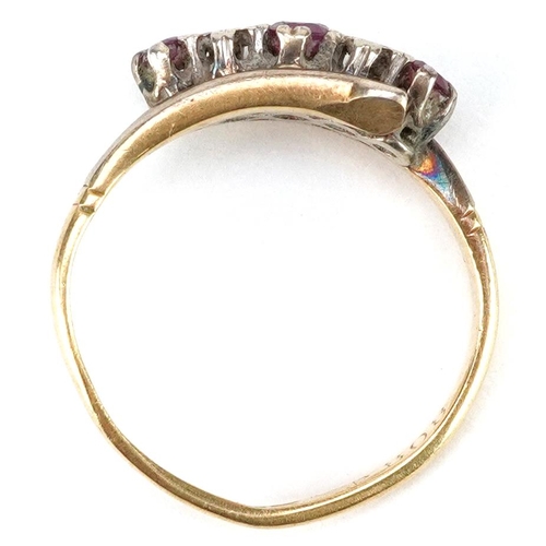 2194 - An 18ct gold and platinum ruby and diamond crossover ring, size J, 2.3g.