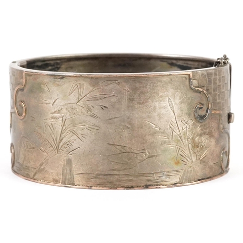 2338 - A large Victorian unmarked silver aesthetic hinged bangle, 6.5cm wide x 3cm high, 43.0g.