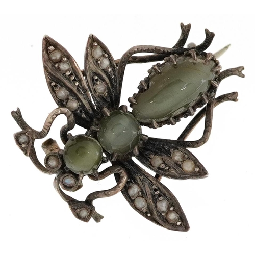 2389 - An antique unmarked silver cat's eye and seed pearl brooch in the form of a fly, 2.5cm in length, 4.... 