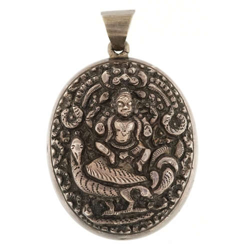 2517 - A large Indian unmarked silver locket pendant embossed with a deity, 6.5cm high, 29.8g.