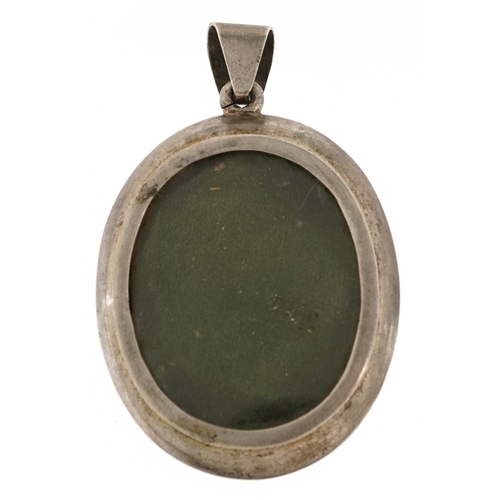 2517 - A large Indian unmarked silver locket pendant embossed with a deity, 6.5cm high, 29.8g.