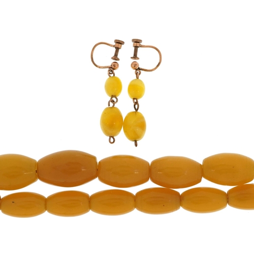 2537 - An amber coloured bead necklace and a pair of similar earrings with yellow metal mounts, the necklac... 