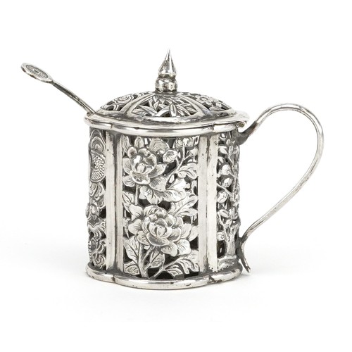 61 - A Chinese export silver mustard with spoon and clear glass liner, pierced and embossed with a dragon... 