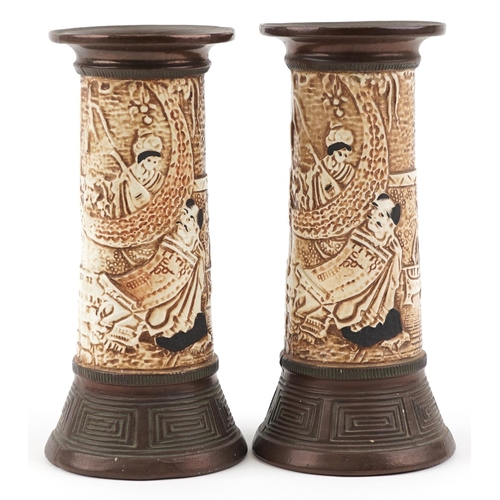 1313 - A pair of Bretby pottery vases relief decorated with Chinese figures, impressed 1839 to the base, 24... 