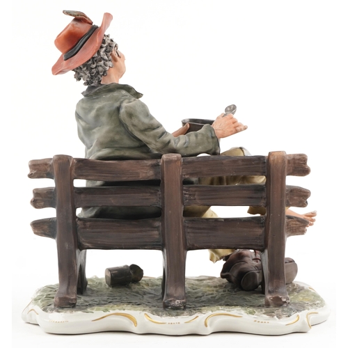 450 - A large 20th century Capodimonte porcelain tramp on a bench group, bearing signature, 33cm H x 33cm ... 