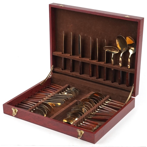 591 - A six place mahogany canteen of bronze cutlery with wooden handles, the canteen 42.5cm wide.