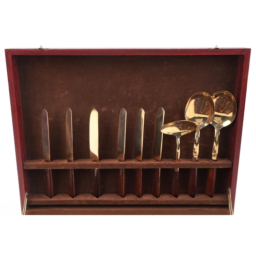 591 - A six place mahogany canteen of bronze cutlery with wooden handles, the canteen 42.5cm wide.