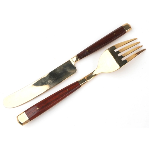 591 - A six place mahogany canteen of bronze cutlery with wooden handles, the canteen 42.5cm wide.