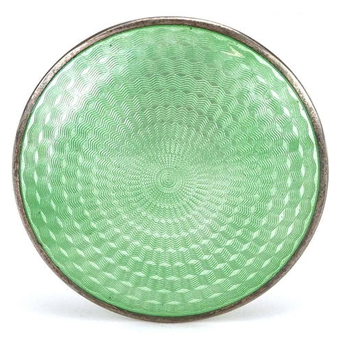  An Art Deco unmarked silver and green guilloche enamel compact, 5.5cm in diameter, 61.6g.