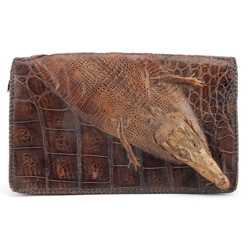 291 - An early 20th century crocodile skin clutch bag, 31cm wide, together with another clutch bag.