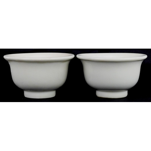 413 - A pair of Chinese porcelain white glazed footed bowls, 9cm in diameter.