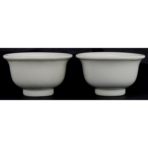 413 - A pair of Chinese porcelain white glazed footed bowls, 9cm in diameter.