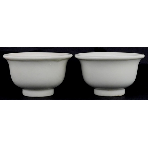 413 - A pair of Chinese porcelain white glazed footed bowls, 9cm in diameter.