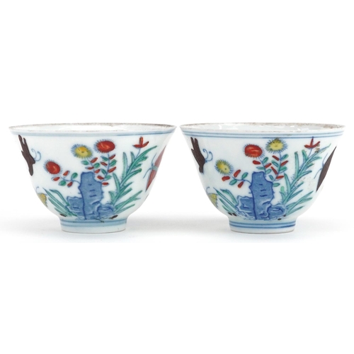 342 - A pair of Chinese porcelain tea bowls hand painted with flowers and insects, six figure character ma... 