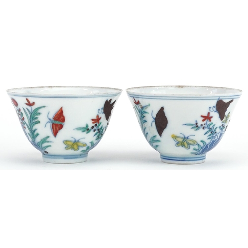 342 - A pair of Chinese porcelain tea bowls hand painted with flowers and insects, six figure character ma... 