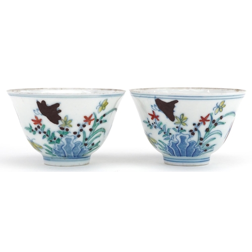 342 - A pair of Chinese porcelain tea bowls hand painted with flowers and insects, six figure character ma... 