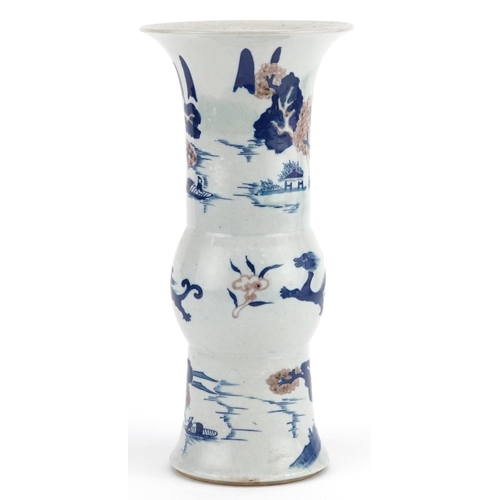 104 - A Chinese porcelain vase hand painted with dragons and pagodas beneath trees, 27cm high.