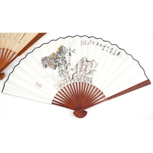 1218 - Two Chinese fans hand painted with flowers and script, 32.5cm in length when folded.